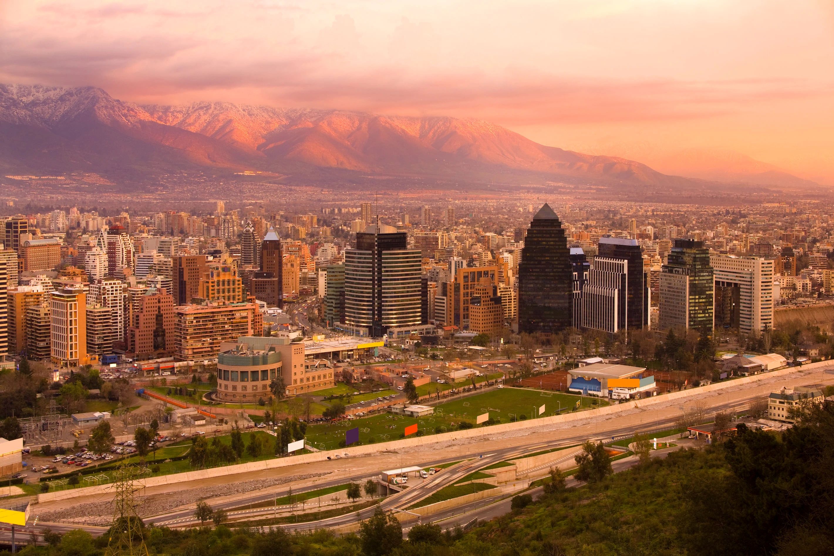 Edificio moderno de departamentos en Las Condes con fachada de vidrio y vista a la cordillera